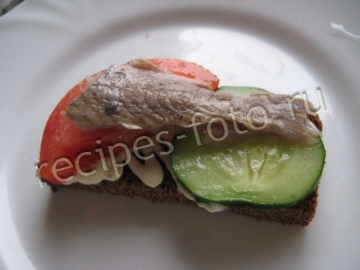Бутерброды с селедкой, огурцом и помидором на черном бородинском хлебе
