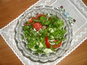 Салат из свежих огурцов, помидоров с листьями салата 